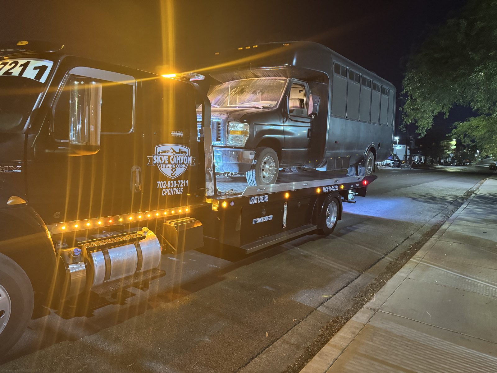 Classic car on a flatbed during a late-night tow in Las Vegas