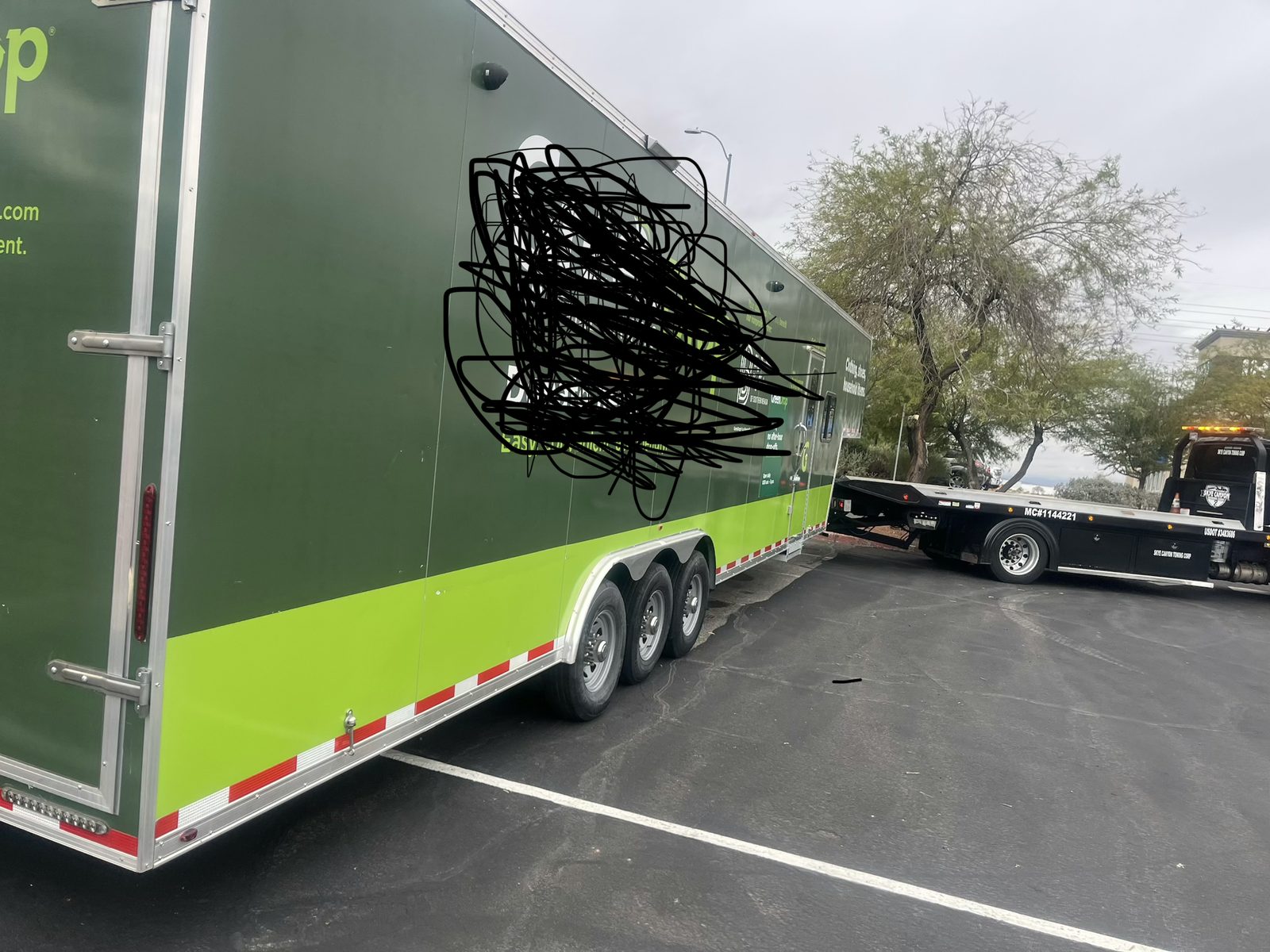 Enclosed race trailer being hauled by Skye Canyon Towing heavy-duty wrecker